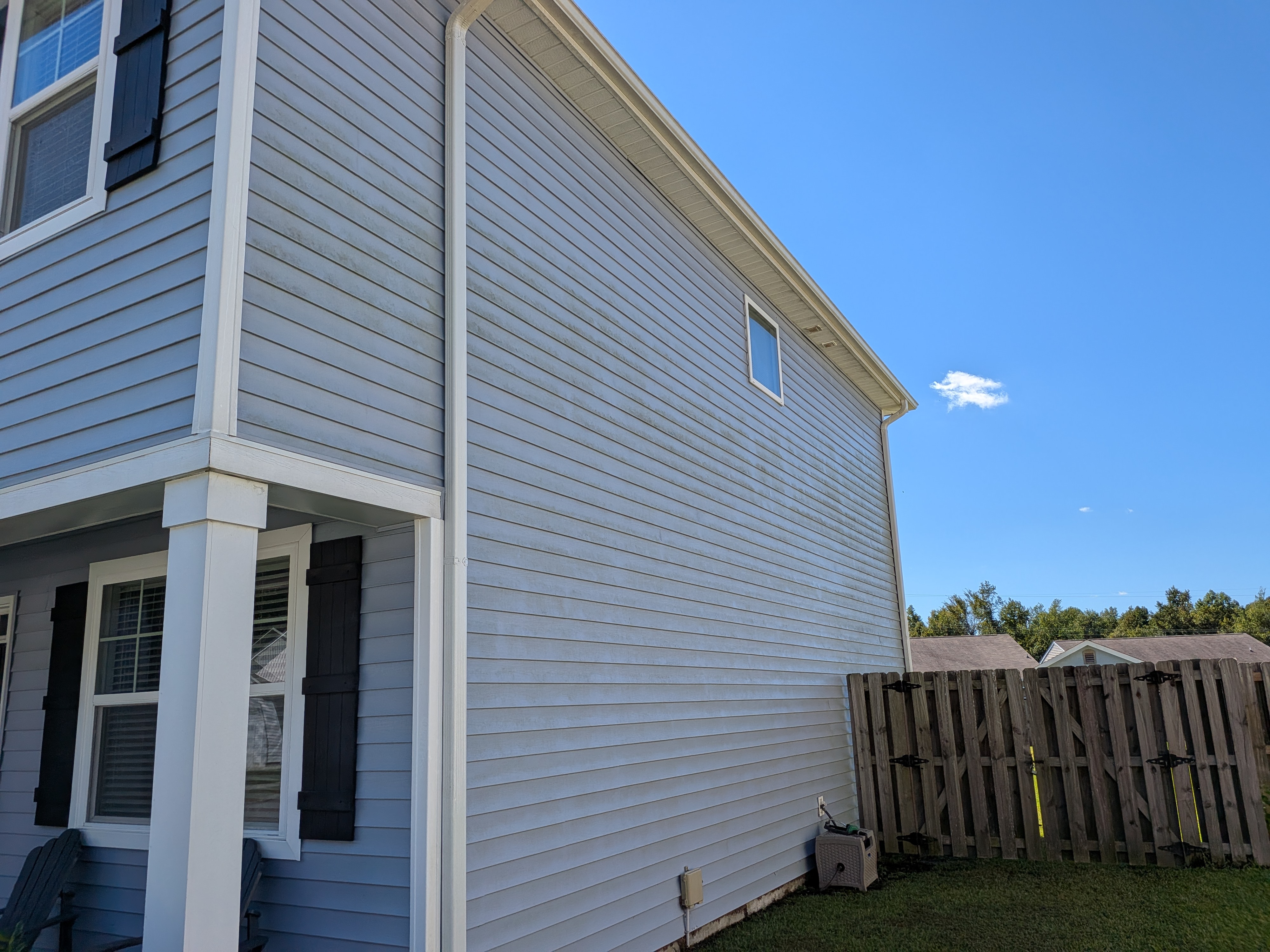 After house washing: refreshed light-colored residential siding along a two-story exterior